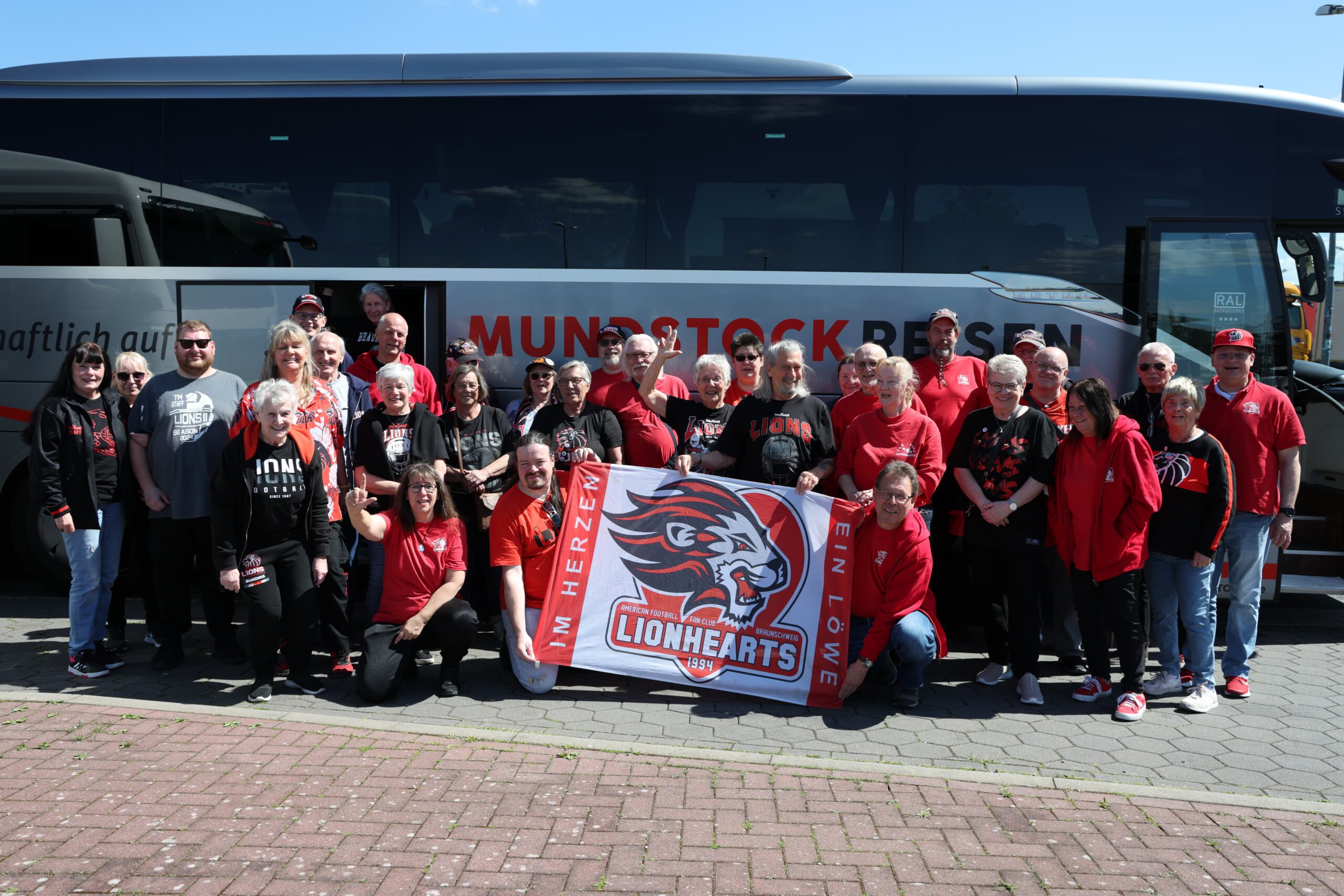 Die Mitglieder des Fanclub Lionhearts haben sich für ein Gruppenbild vor dem Reisebus zusammengefunden